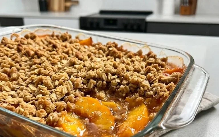 Delicious homemade Peach Crisp topped with oat crumbles and fresh peaches